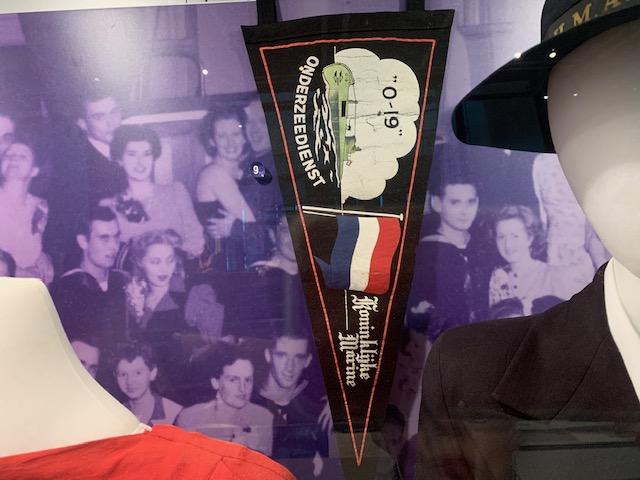 A triangular pennant featuring an image of a submarine and a Dutch flag.