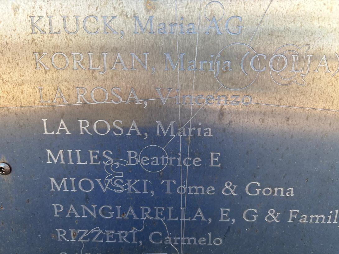 A close up of a silver panel inscribed with names.