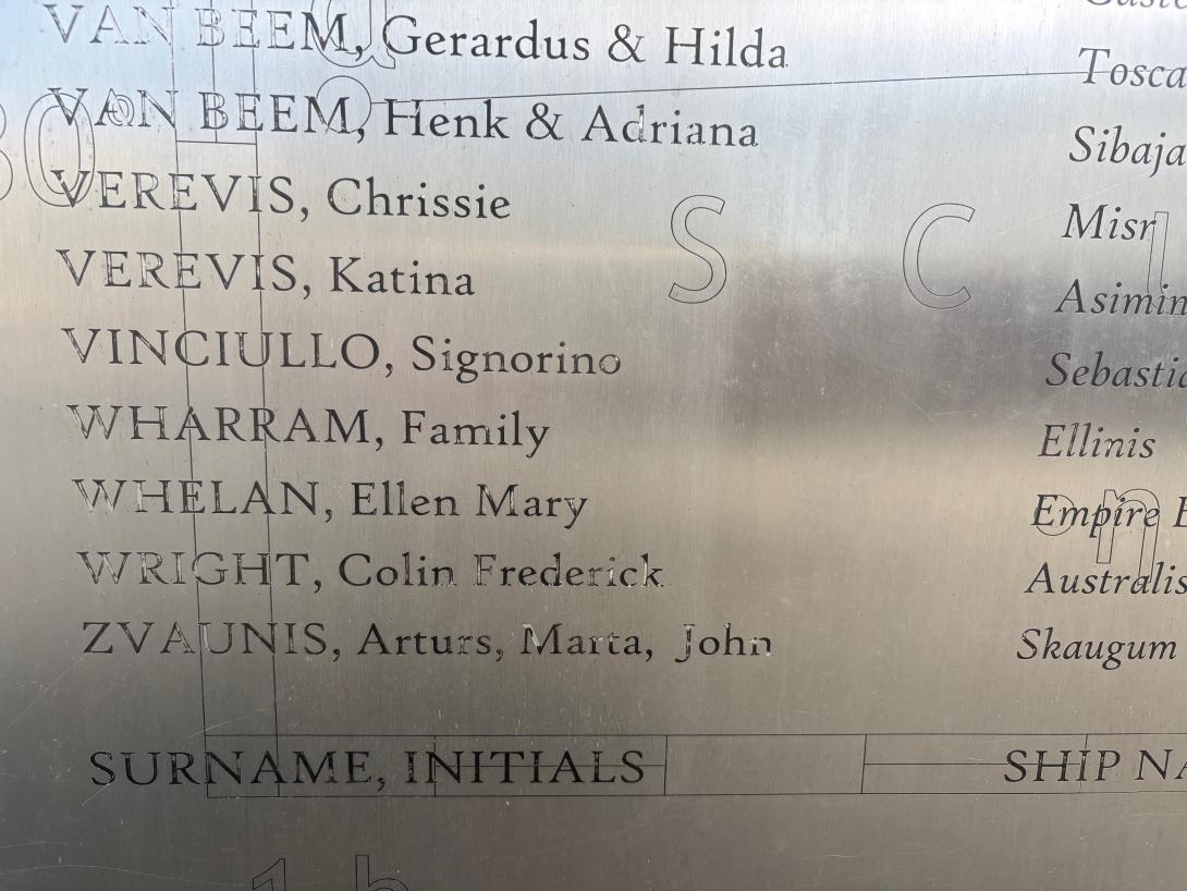 A close up of a silver panel inscribed with names.
