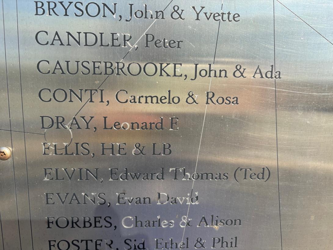 A close up of a silver panel inscribed with names.