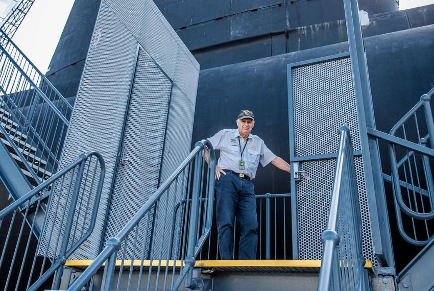 One of our experienced volunteer tour guides awaits a tour group from the submarine's walkway.