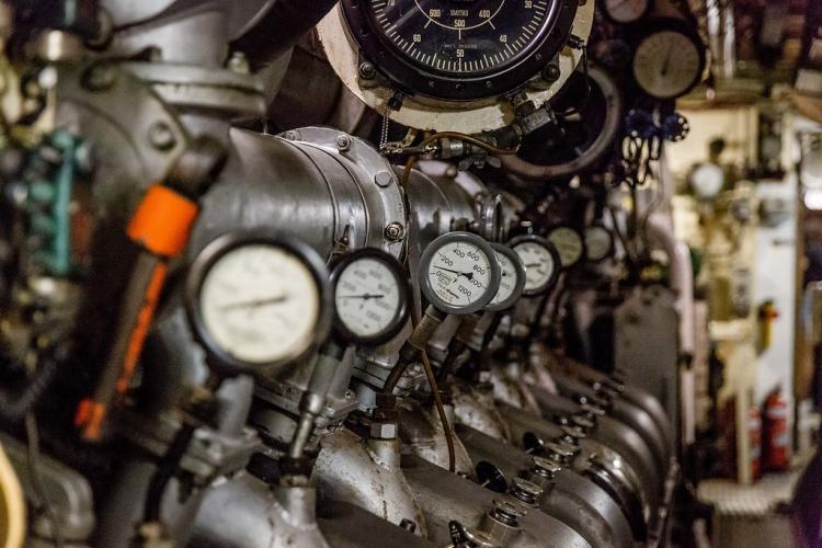 A long, neatly aligned row of pressure measurement dials mounted on one of the sub's huge engines.