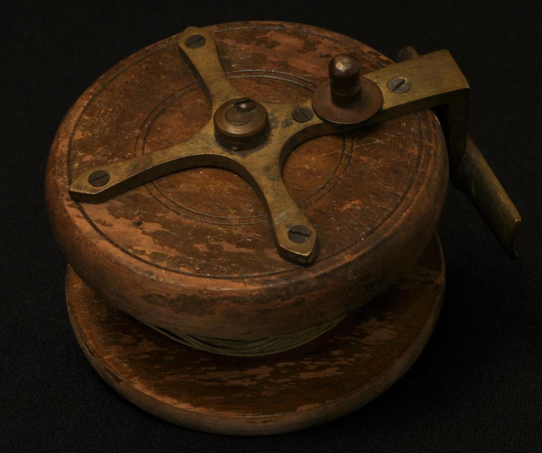 A wood and brass fishing reel.