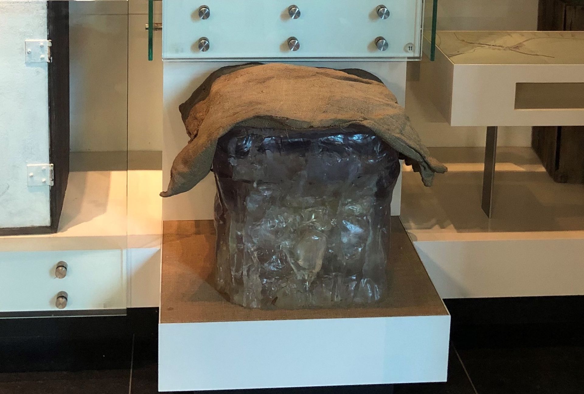 A model of a large block of ice, with a hessian sack draped over the top.