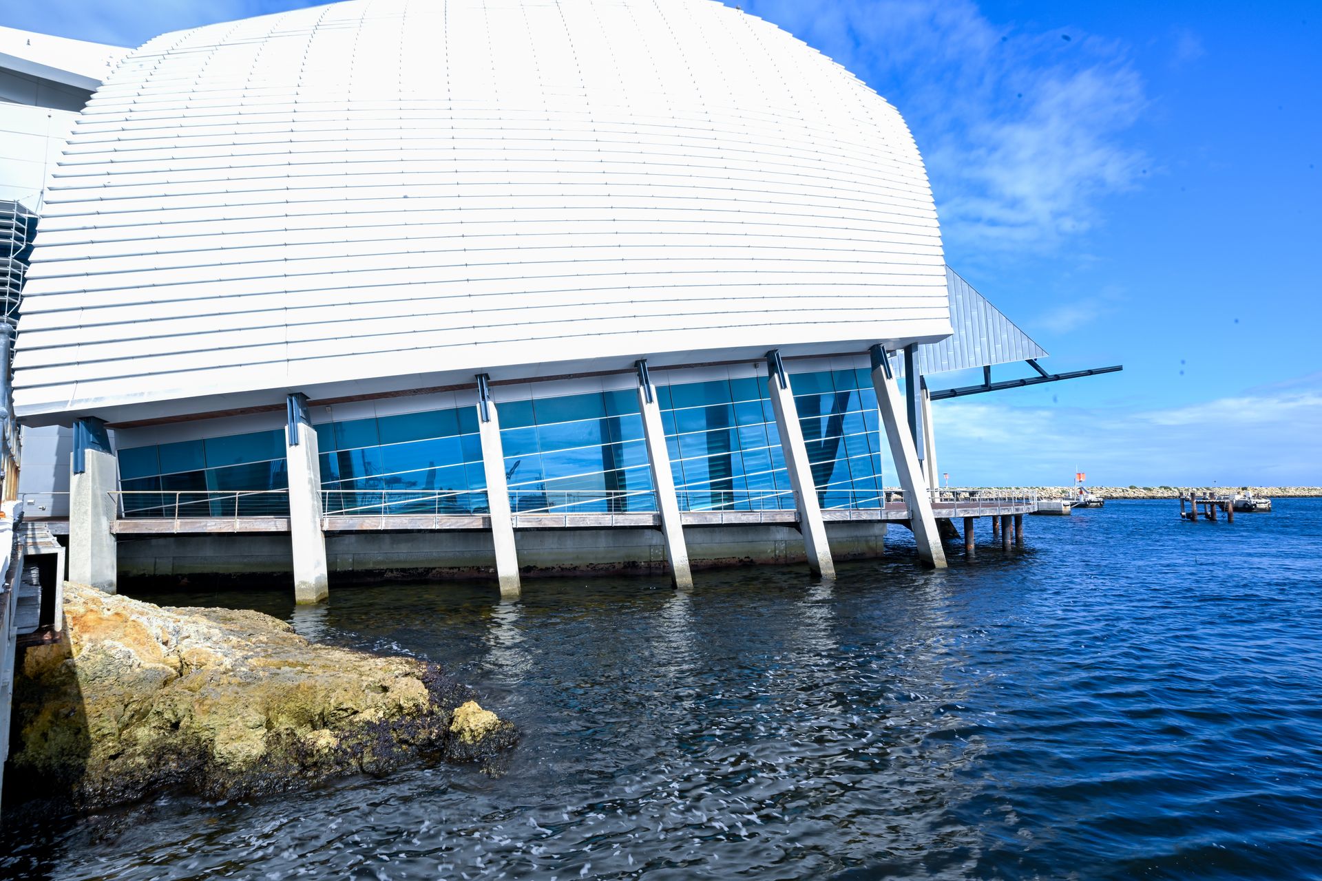 Looking from the water at the outside of the Museum, a rock formation can be seen above the surface.
