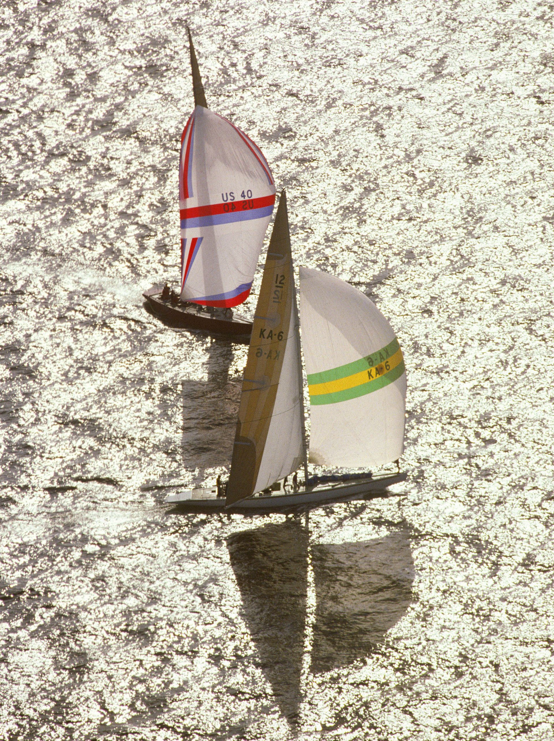 Two yachts sailing quickly beside one another, the Australia II is just ahead of the American yacht.