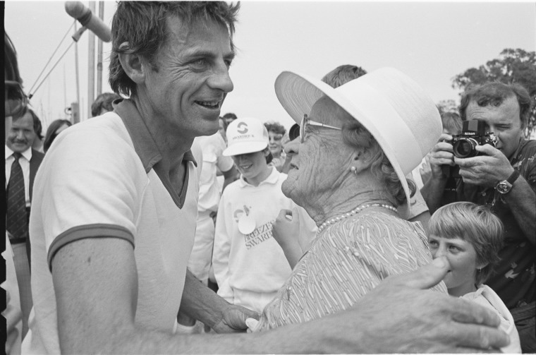 Jon Sanders about to hug his elderly mother in front of a large crowd of supporters.