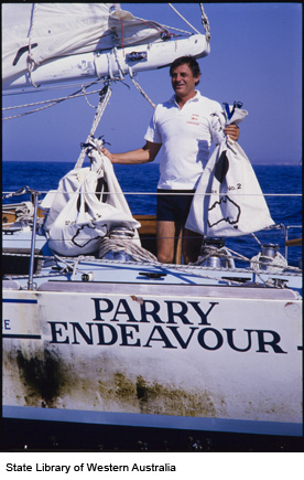 Jon grins as he holds up two large white sacks on the deck of the yacht.