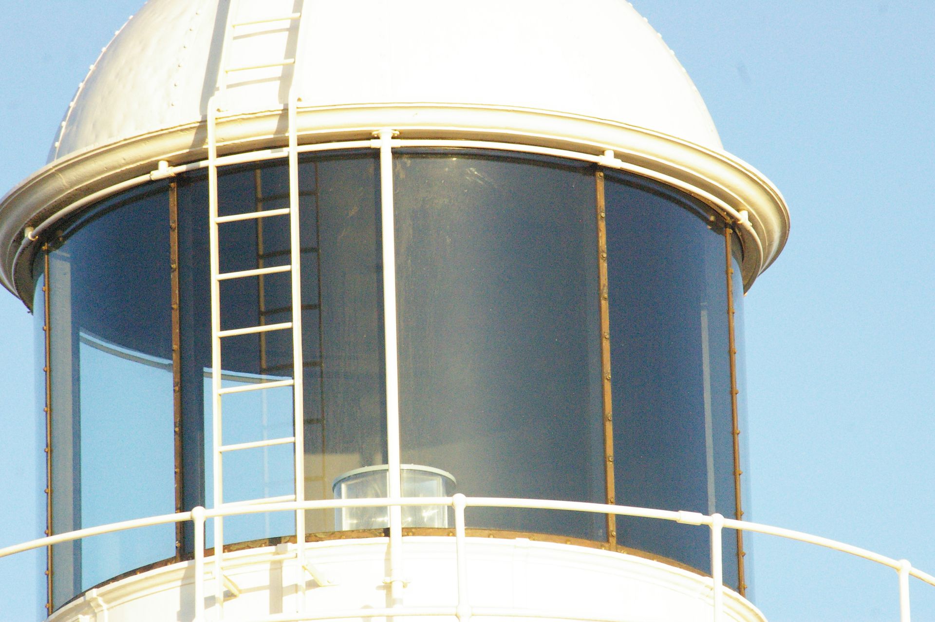 The white painted dome of a lighthouse gleaming in the sun.