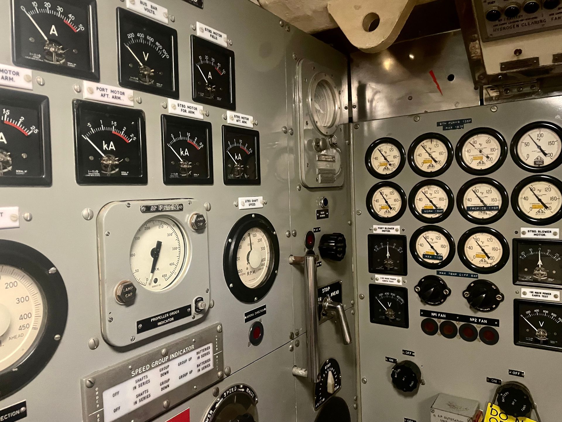 Many square and circular dials mounted in two grey metal panels. Labels read, for example, "Bus Bar Volts," "Speed Group Indicator," and "Port Blower Motor."