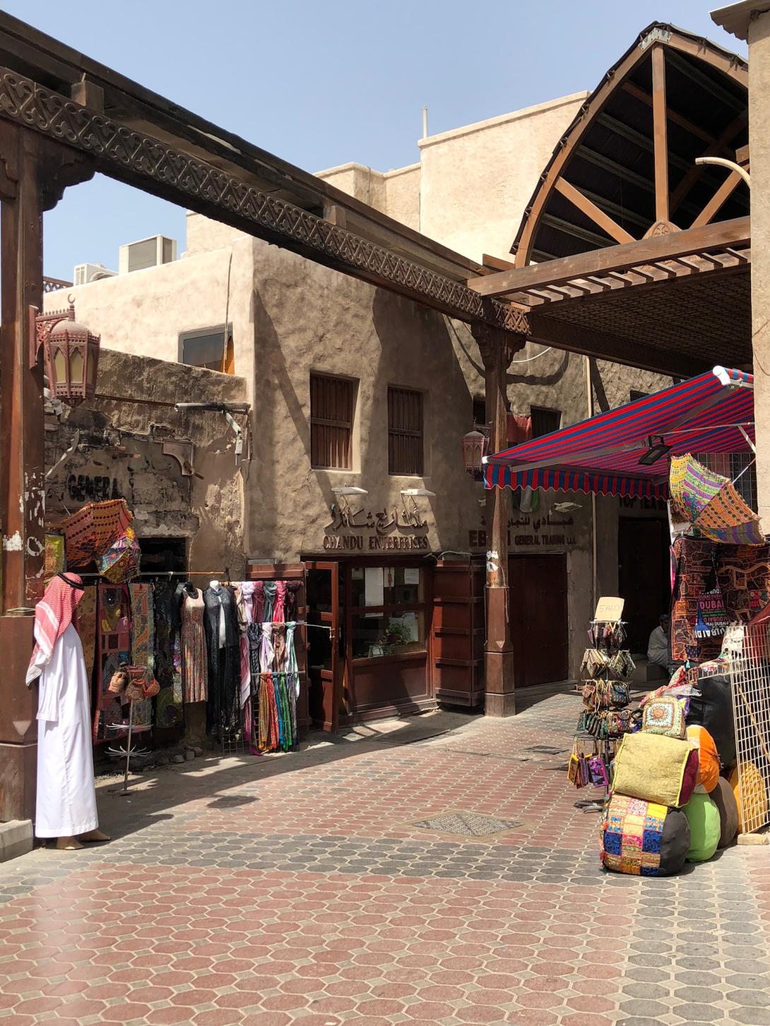 A marketplace with colourful clothing on display.