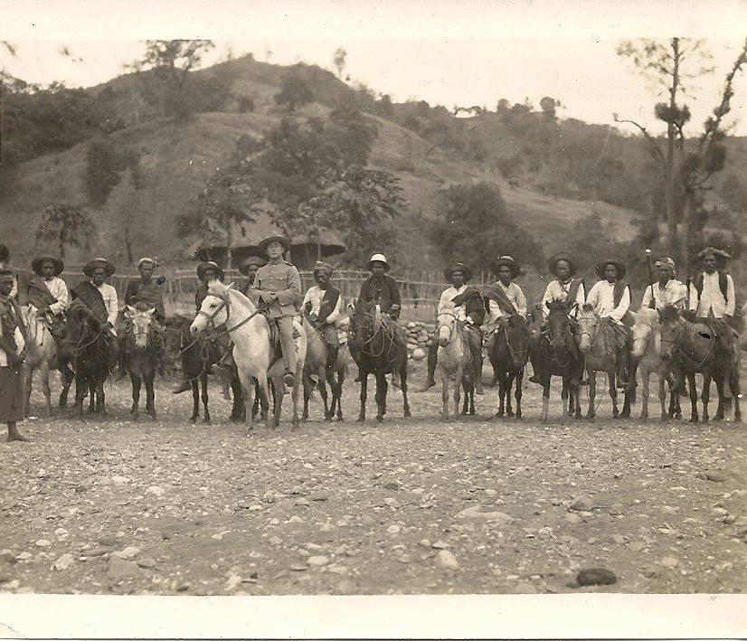 Old photograph of a white European on a horse in front of a line of mounted East Timorese men.