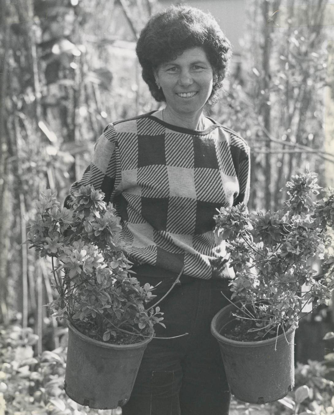 Lena stands carries the plants amongst the tall greenery.