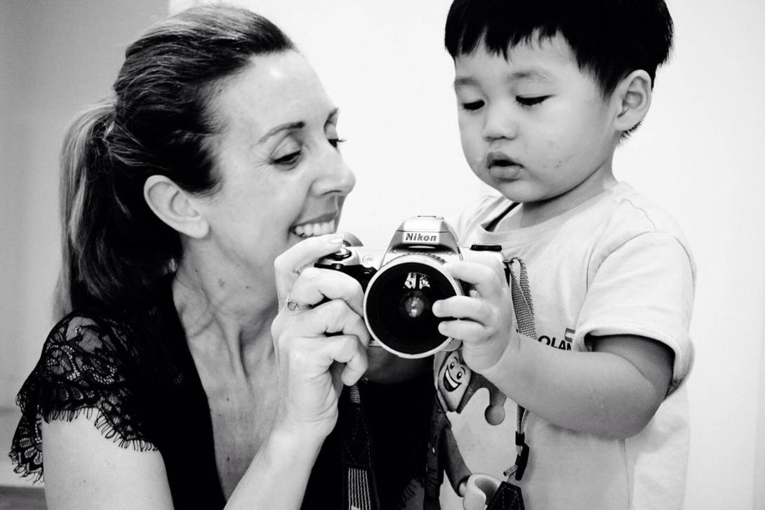 Tina showing a young child how to use a photographic camera.
