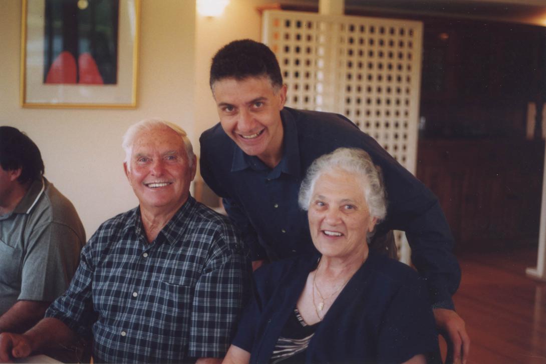 Tony leans over to join the happy older couple.