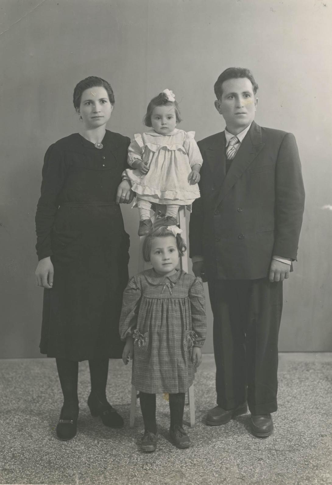 The families are perhaps unused to cameras as, unsmiling, they all look to the side in this studio portrait.