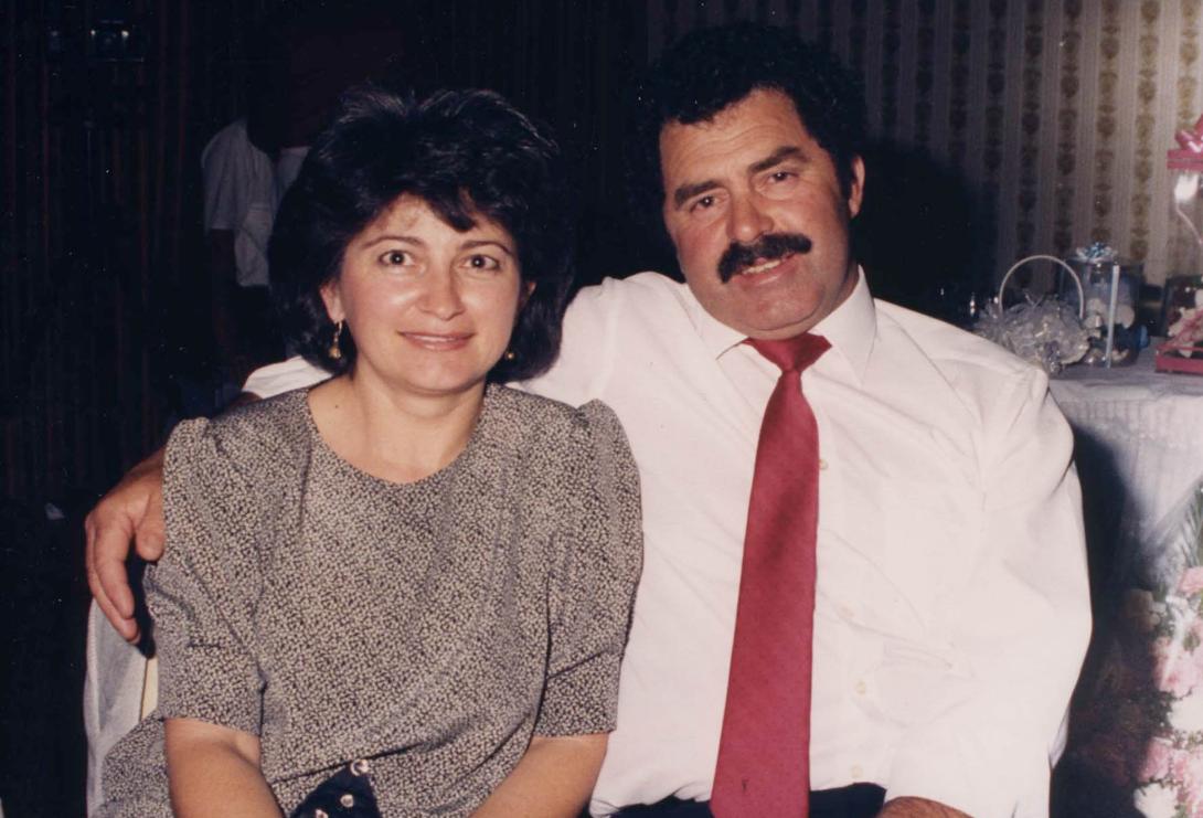Jimmy has a thick moustache, he leans back casually with his arm around Anna.