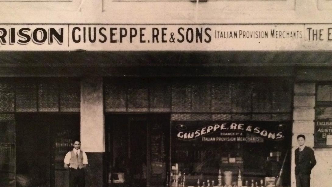The store's sign reads "Giuseppe Re & Sons Italian Provision Merchants."