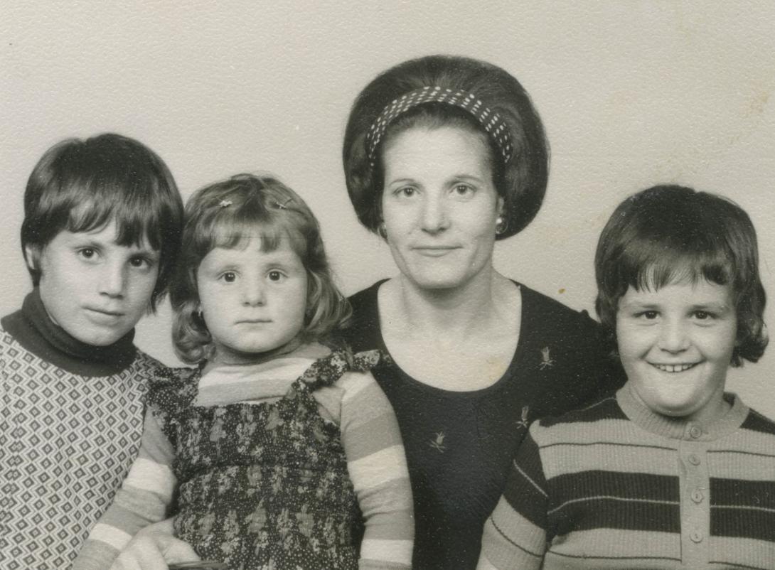 Three children with Adele, her arm around the youngest girl.