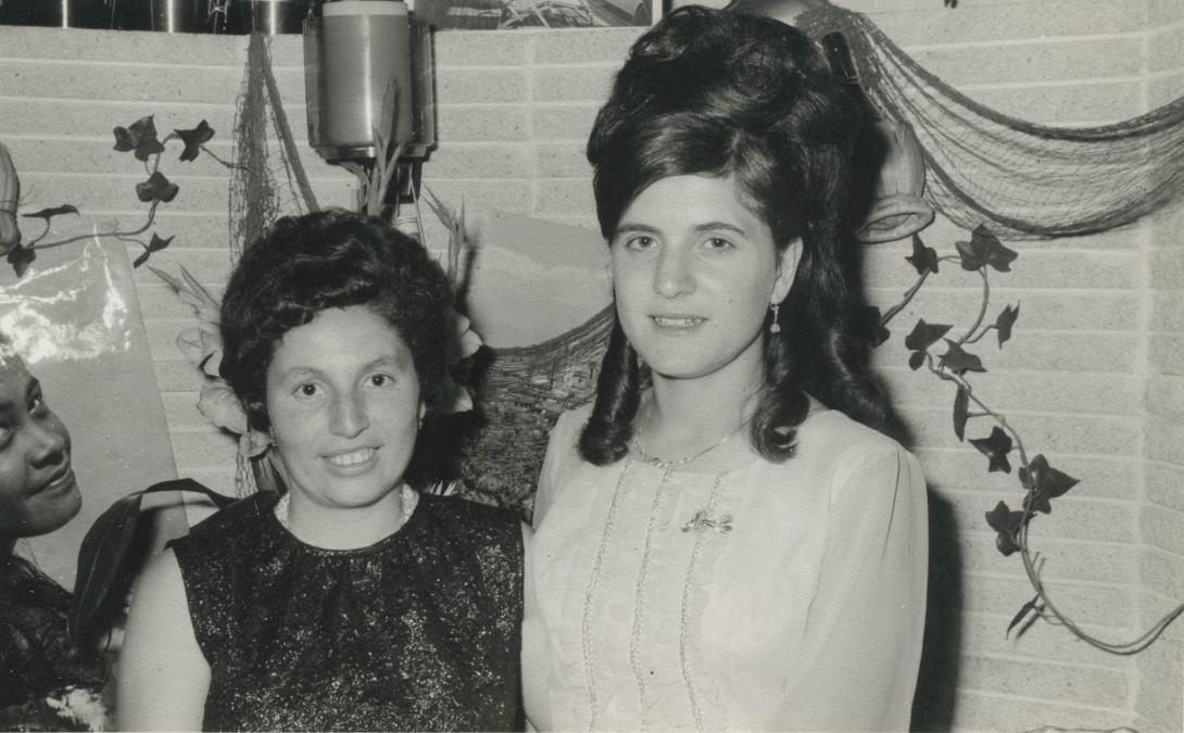 Two women standing together, their hair done up for a special event.