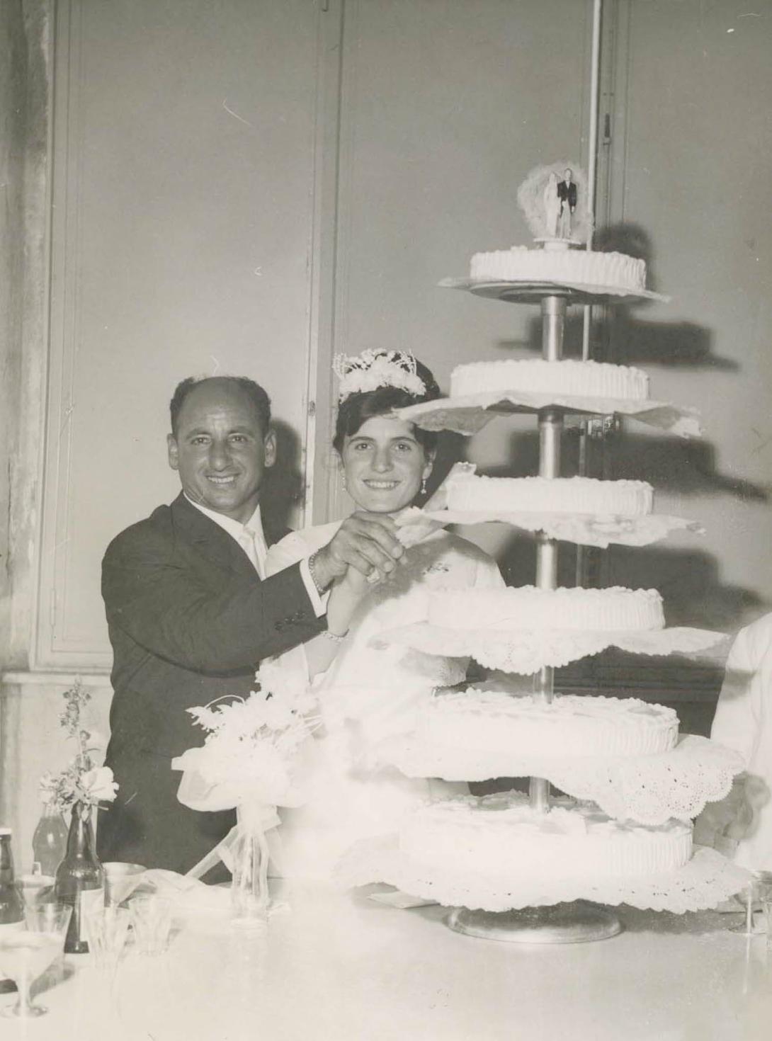 The couple cutting a very large wedding cake.