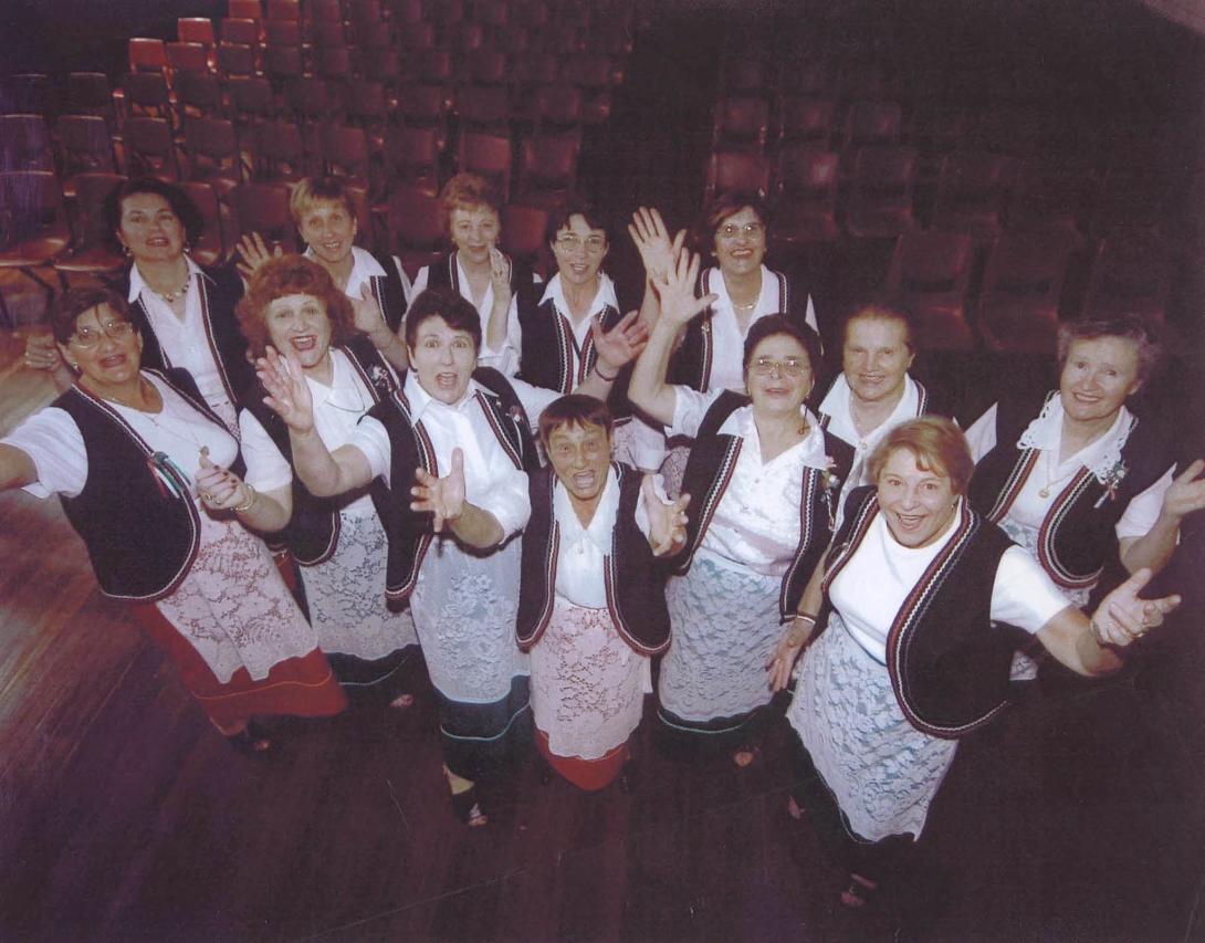 Photo taken from on high, the choir looking up waving their hands.