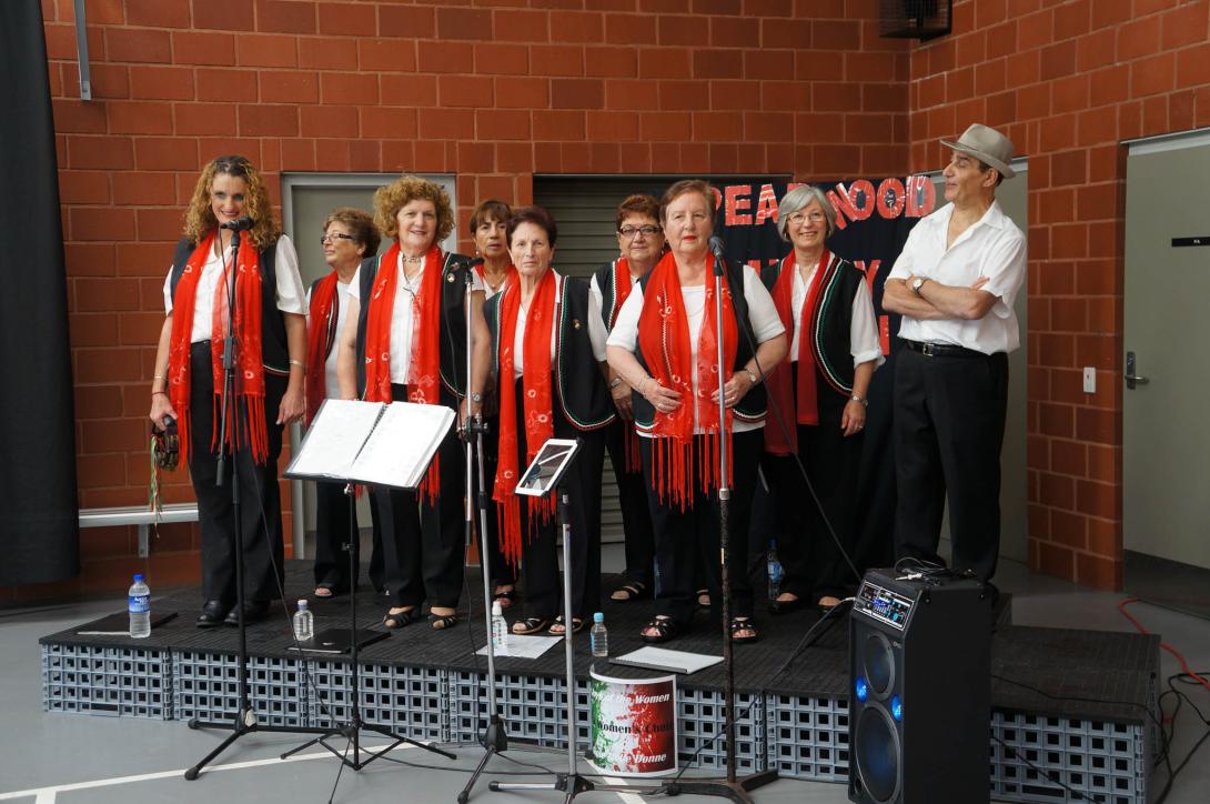 The choir on stage in front of a sign reading "Spearwood."