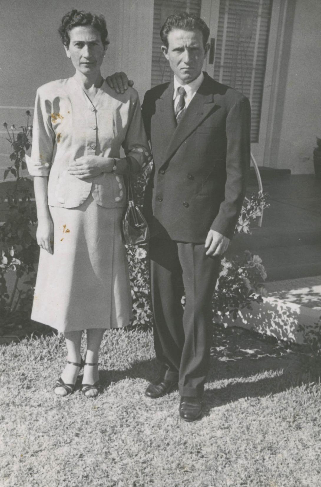 A few yellow stains spot this photo of the couple dressed in formal wear in front of a house.