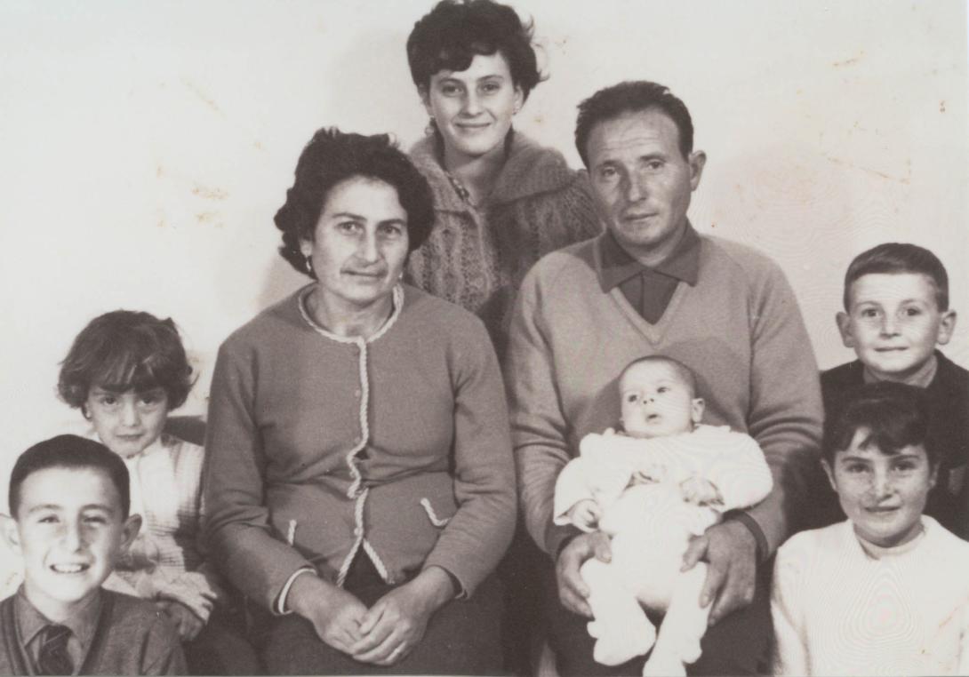 Five smiling children surround the parents, the baby rests on Francolino's lap.
