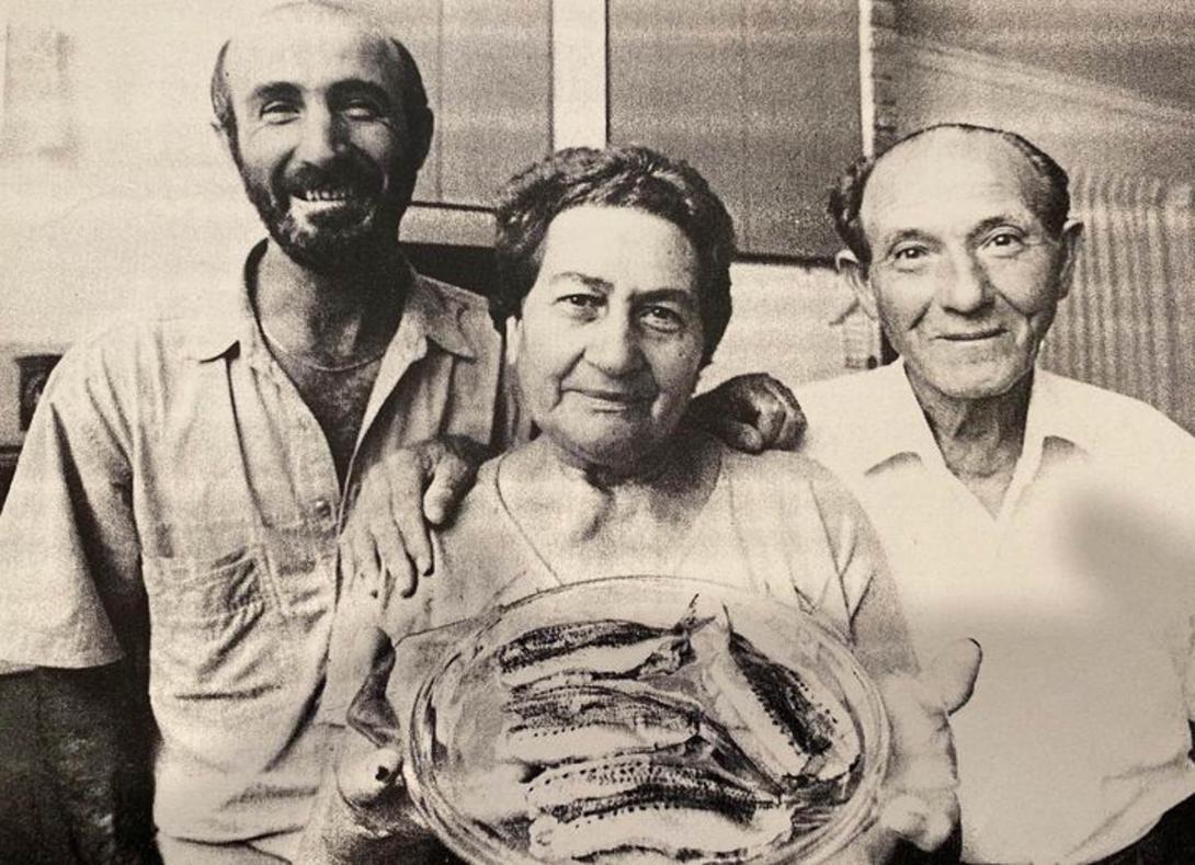 A grainy black and white photo, taken from a newspaper or photocopy with the three people and sardines.