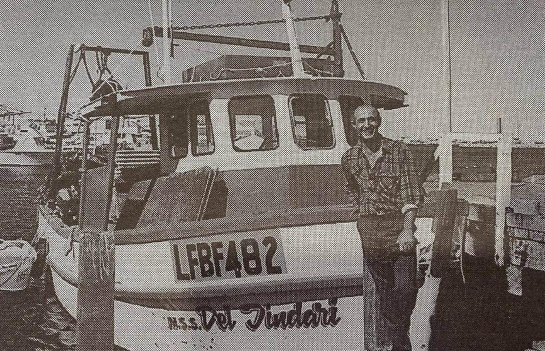 Newspaper photo of a smiling Jim at dock with the fishing boat.