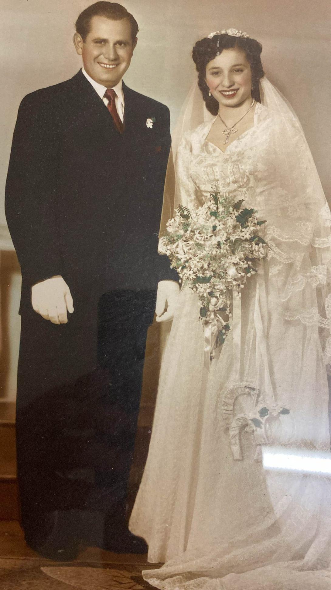 The couple smiling, Frances clutching a large bouquet of flowers.