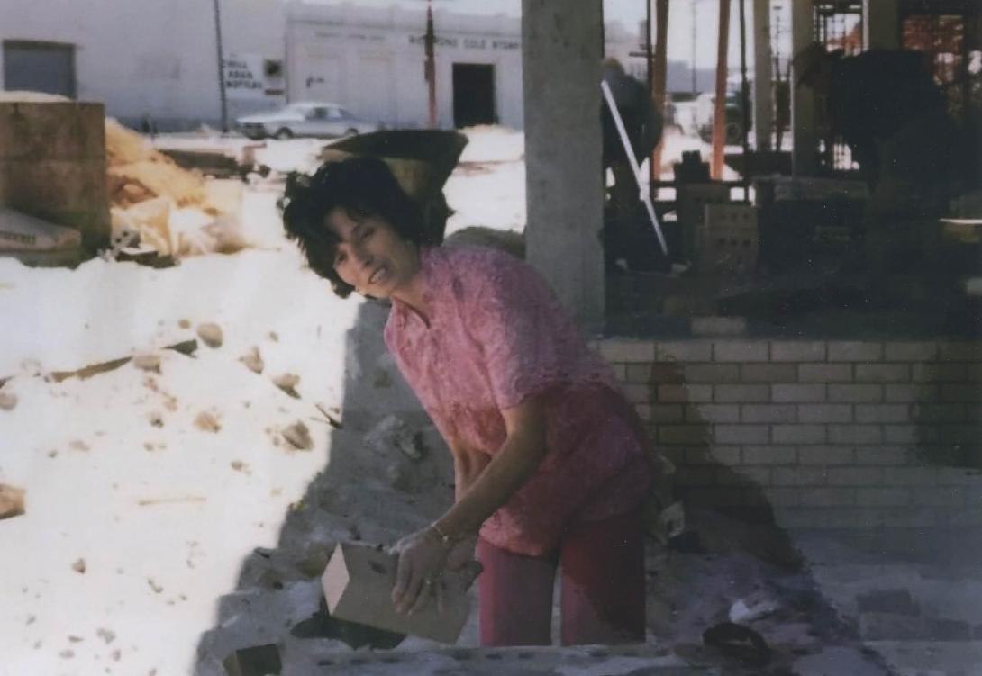 Frances at the worksite, in a pink shirt not bricklaying clothes.
