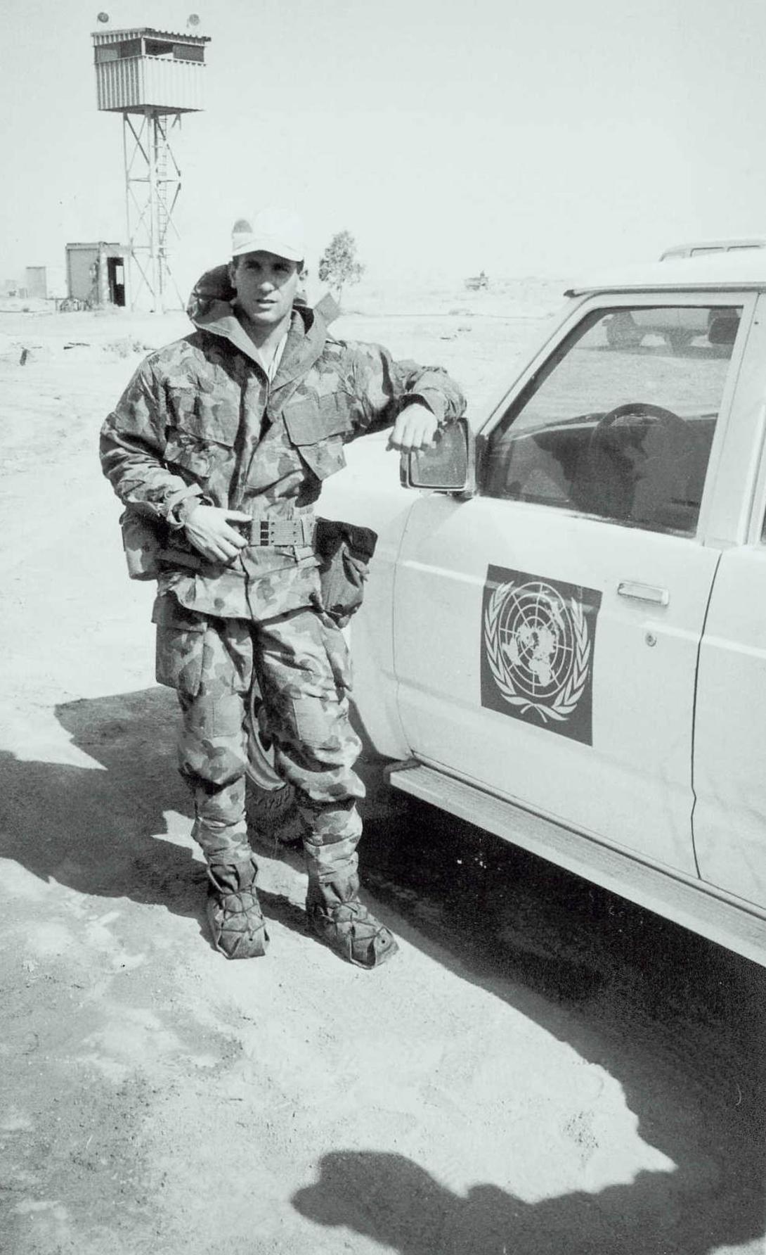 Paul in military fatigues leaning against a vehicle with the UN logo.