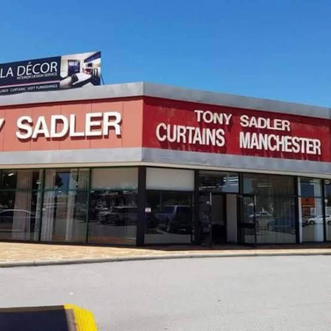 A later photo after some renovations. In a more modern font: Tony Sadler - Curtains Manchester