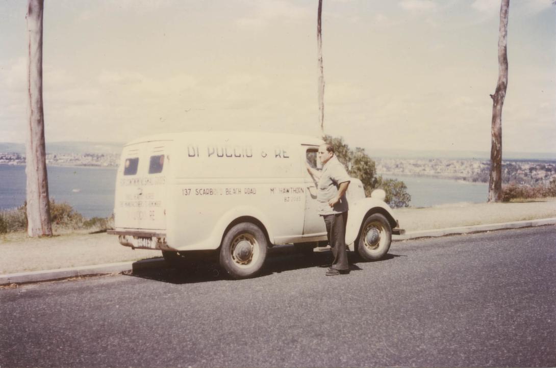 A white van parked on a hill with the river stretching behind.