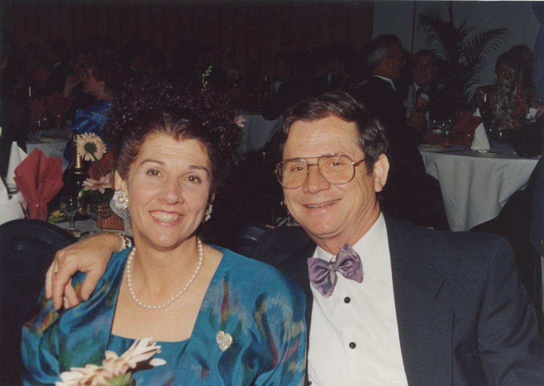 The couple seated, embracing for the camera.