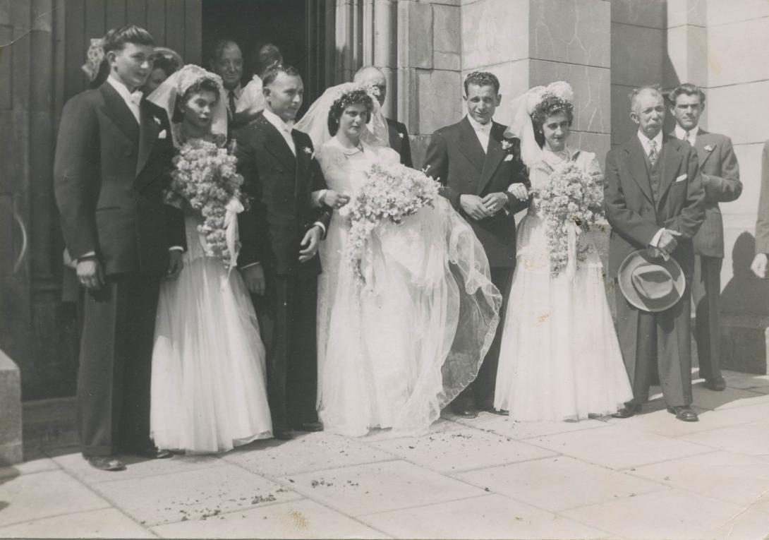 A candid shot of the wedding party from the side, preparing for the wedding photographer's next group shot.