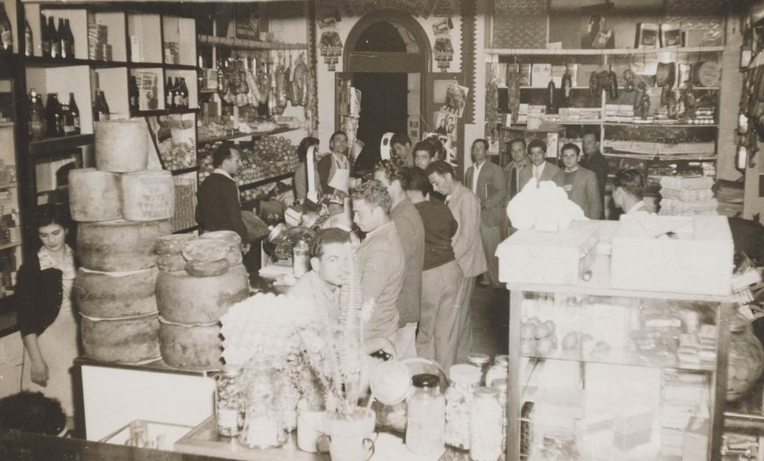 A crowd of mostly young men queue up for service between the well-stacked shelves.