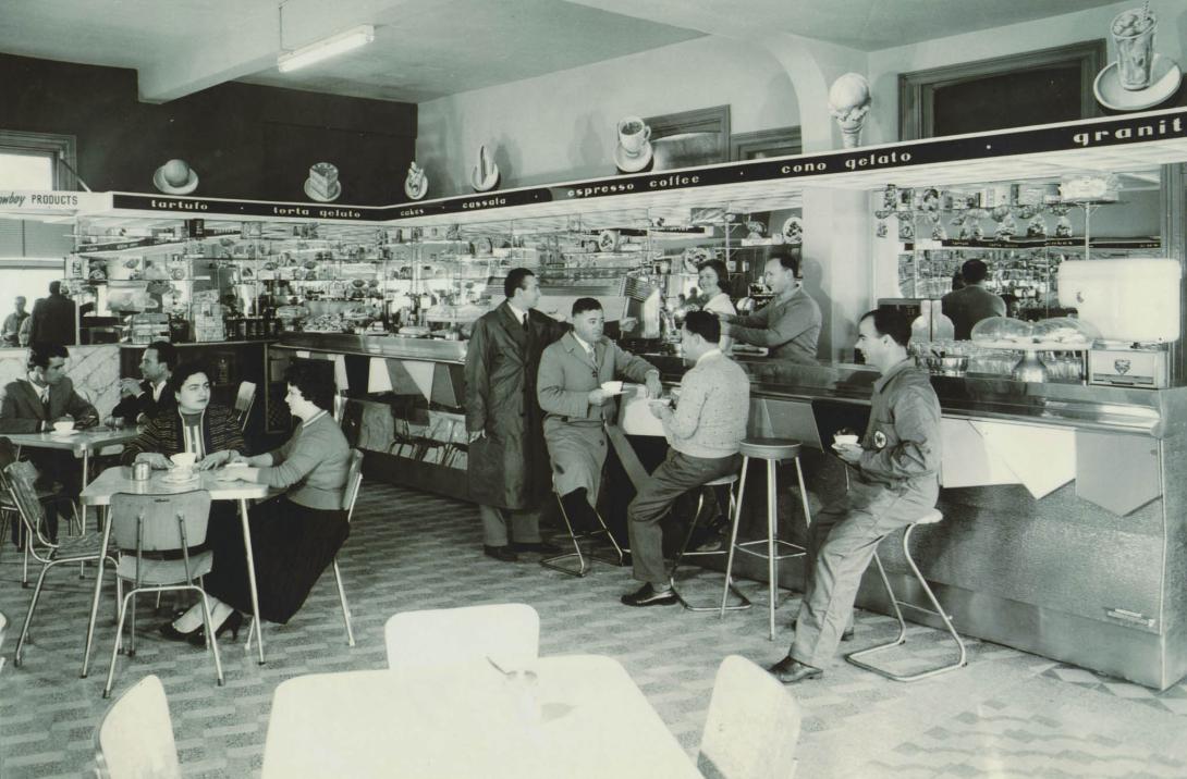 Conversations happen between customers around tables as they sip their cups of coffee.