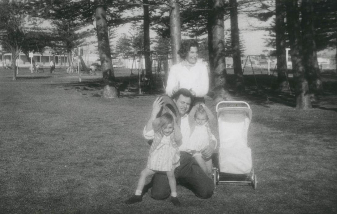 The children clutch their hair as a hat blows off into Dad's face in the strong wind