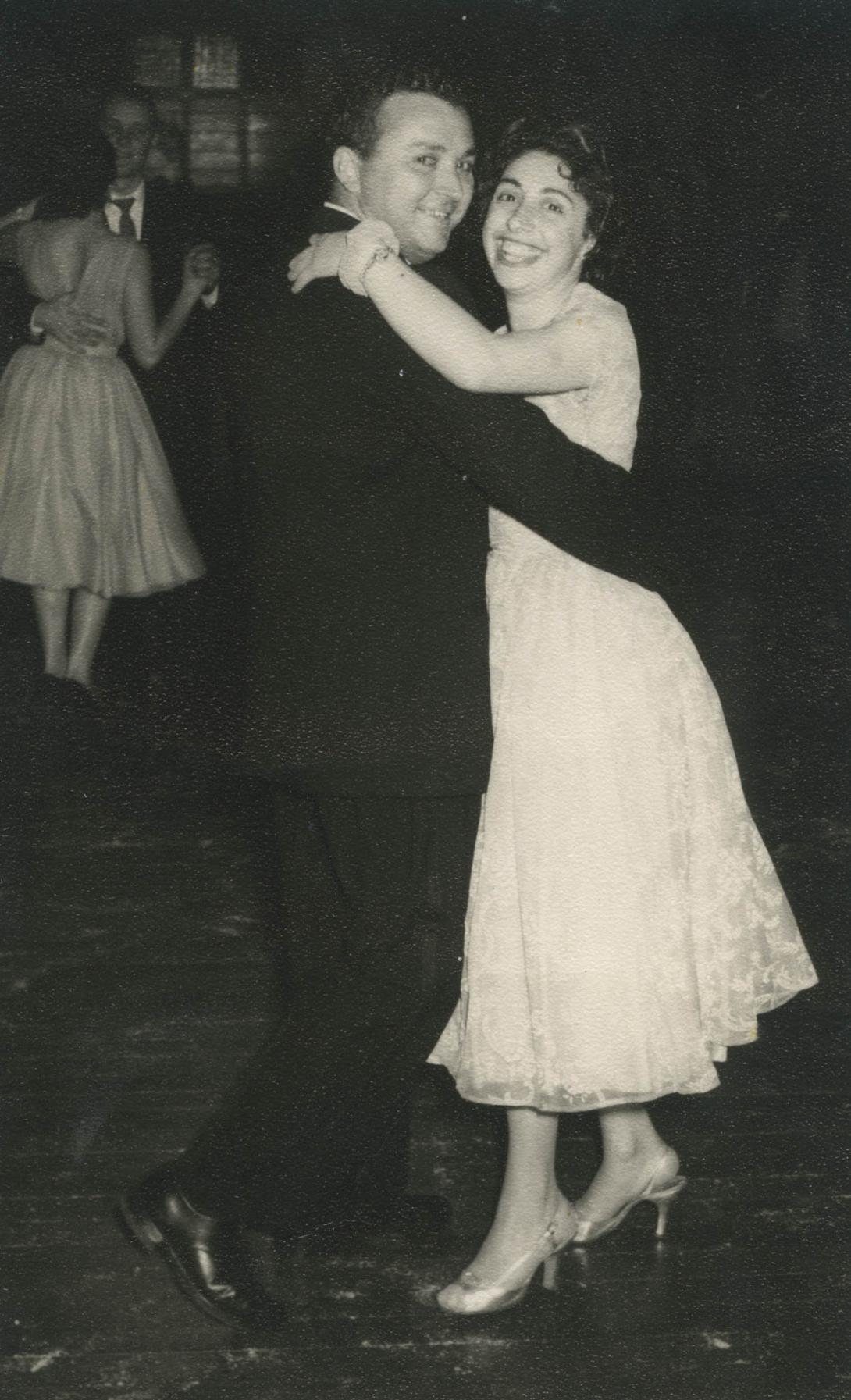 The happy couple dancing in a tight embrace.