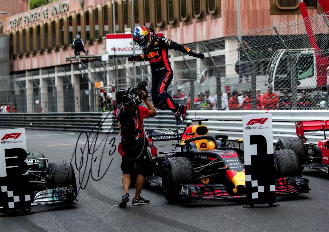 A signed photo of Daniel leaping from the cockpit of the racing car in triumph, still wearing his helmet.