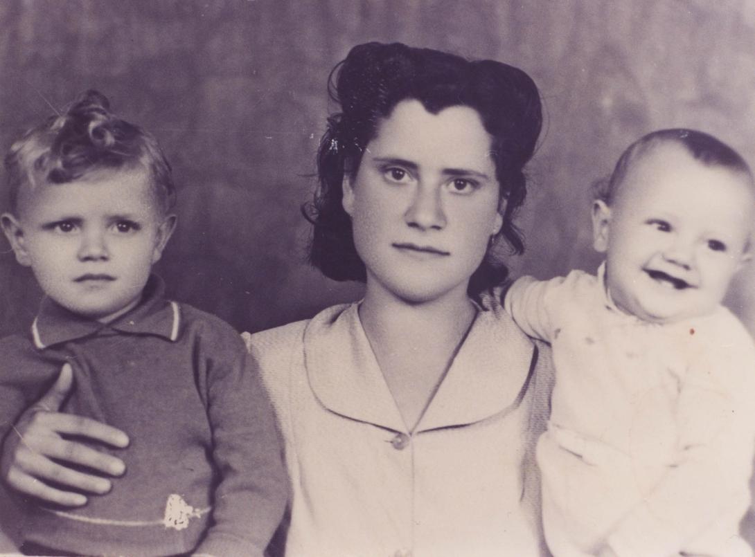 Studio portrait of Giuseppina holding up the small boy and baby.
