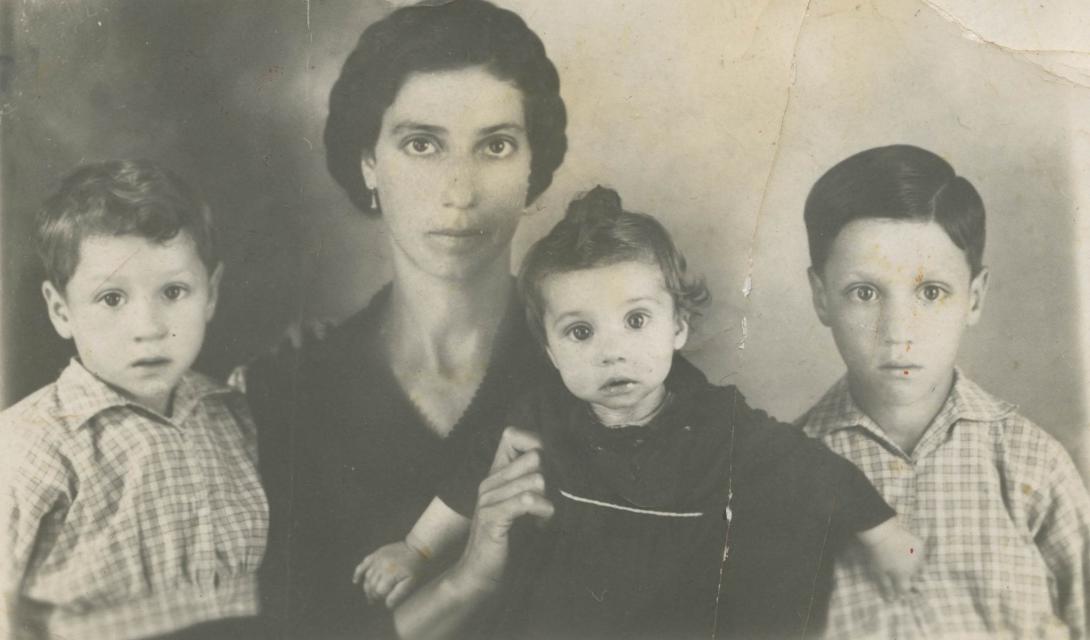 Yellowed and cracked studio portrait of Paola with the three young children.