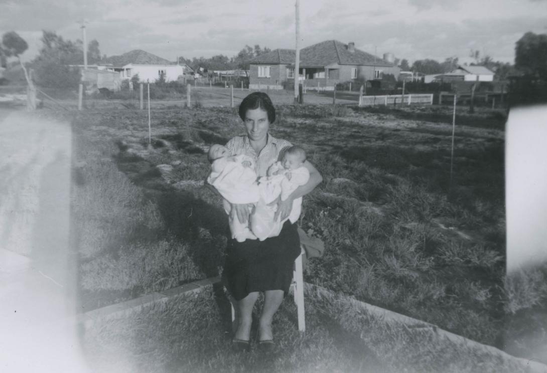 Paola holding up two tiny babies.