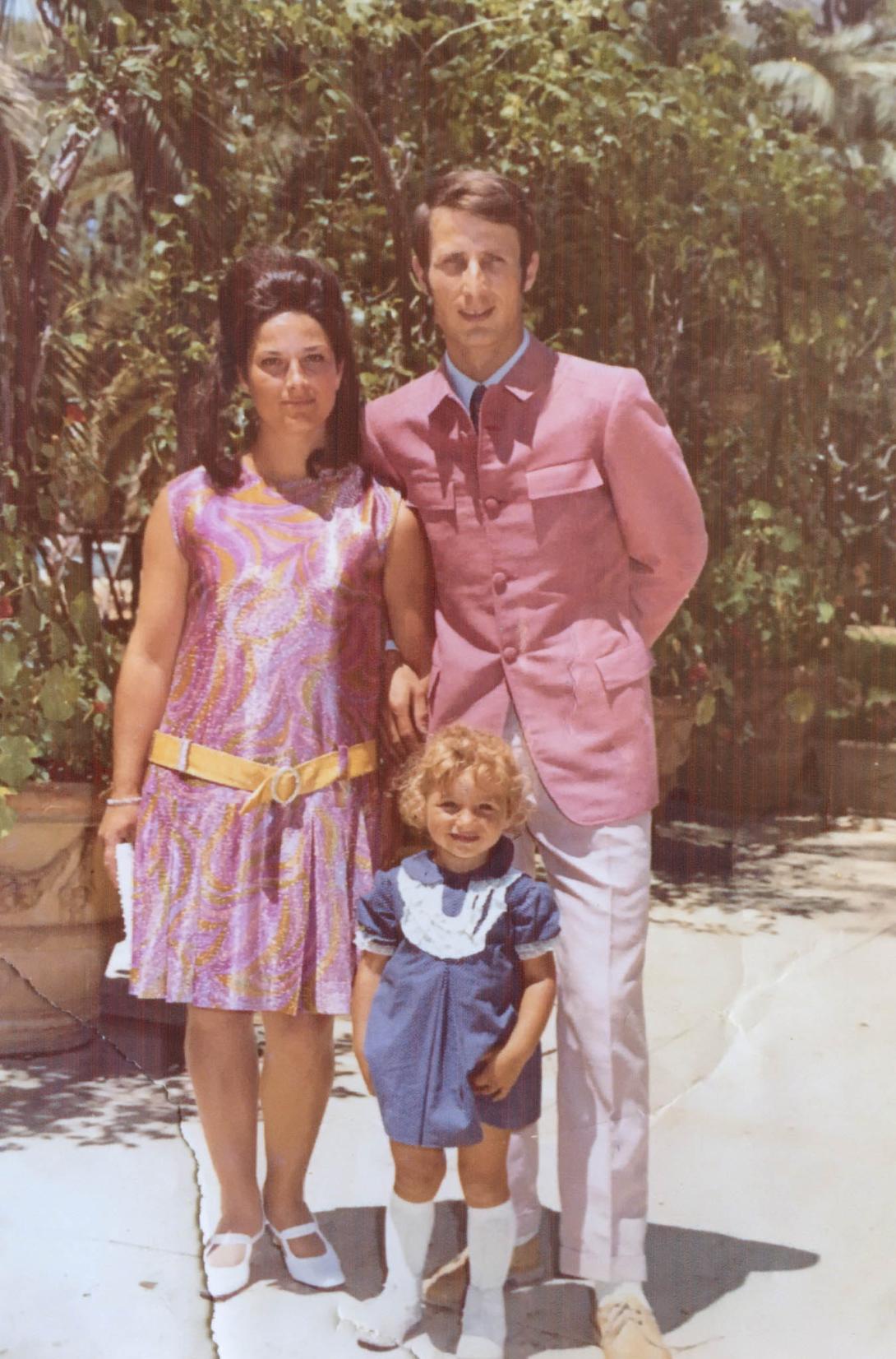 Fabrizio wears a stylish pink jacket. Franca is in a short sleeved shiny dress.