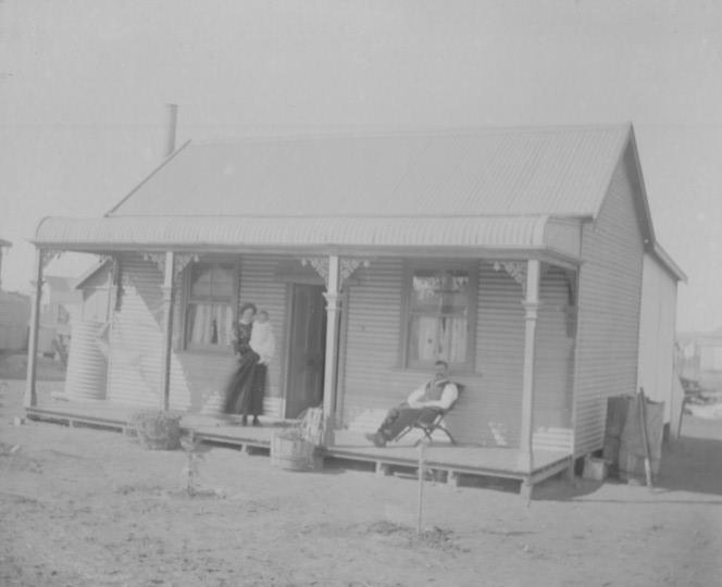 House in Trafalgar, Man seated in chair Douglas William GRAY and woman standing holding small child