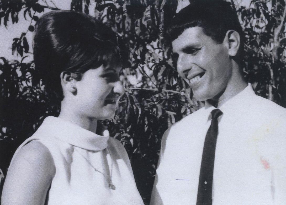 Rosie in white sleeveless dress smiling with Cosimo in white shirt and black tie.