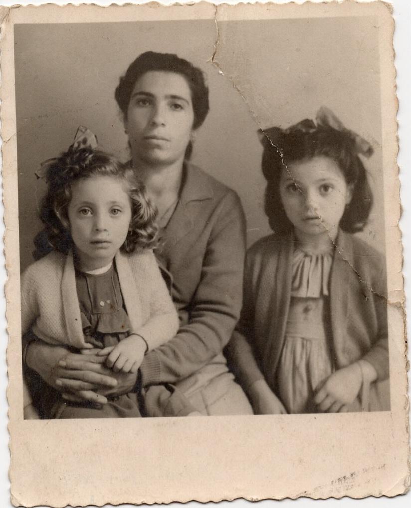 The photo is yellowed and is sadly torn across one girl's face. There is sticky tape residue along the tear.